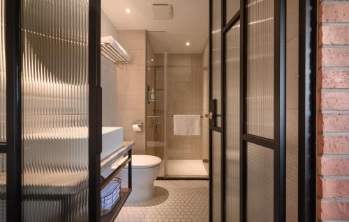 台中的住宿－台中東旅，带浴缸、卫生间和淋浴的浴室。