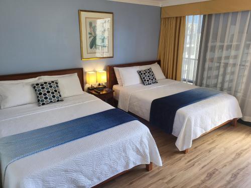 um quarto de hotel com duas camas e uma janela em 21st Floor Renovated Studio with 2 Queen Beds em Honolulu