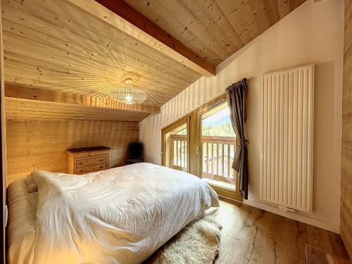 une chambre avec un lit et une fenêtre dans l'établissement Bel appartement 4 pièces près du village, parking inclus - FR-1-560-115, à Combloux