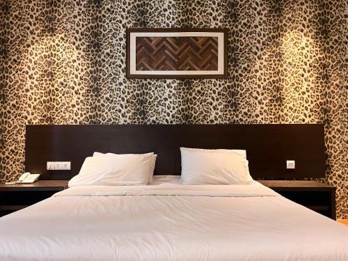 een slaapkamer met een wit bed met een zwart hoofdeinde bij Cube Plus Signature Hotel OUG Kuala Lumpur in Kuala Lumpur