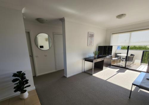 an empty living room with a desk and a mirror at Oceanic on Thompson Apartments in Cowes