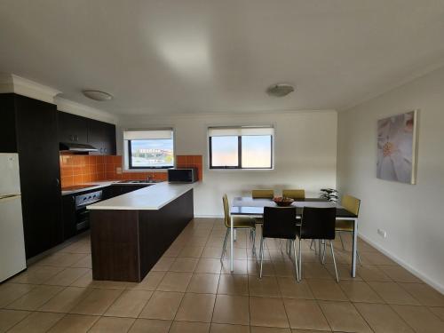 a kitchen with a table and chairs in a room at Oceanic on Thompson Apartments in Cowes