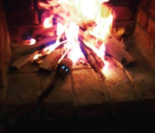 ein Feuer in einem Steinofen mit Apertur in der Unterkunft Rancho los Emilios in Alausí