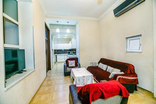 een woonkamer met een bank en een tv bij Квартира у Театра Р. Бейбутова. in Baku