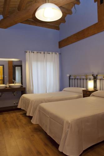 a bedroom with three beds and a mirror at La Casona de la Mesta in Almajano