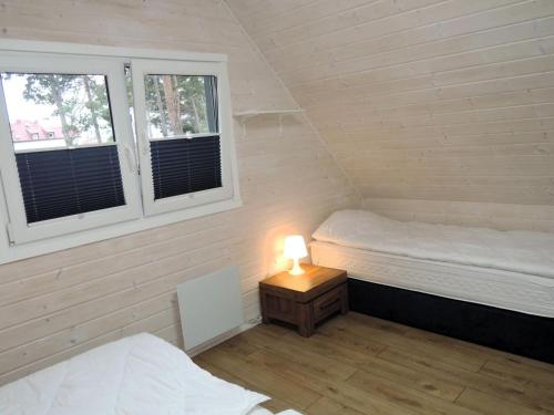 um quarto com duas camas e um candeeiro sobre uma mesa em Comfortable holiday homes for 6 people, close to the sea em Dziwnówek