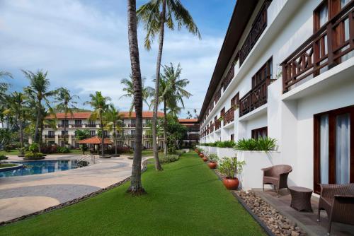 Sheraton Lampung Hotel في بندر لامبونغ: اطلالة على ساحة منتجع فيه نخيل