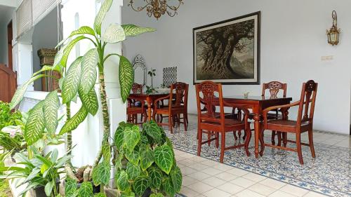 uma sala de jantar com mesas, cadeiras e plantas em Griya Asih em Yogyakarta