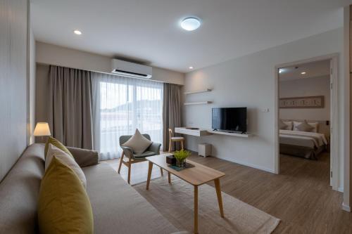 a living room with a couch and a bed at Kantary Hotel Banchang in Ban Chang