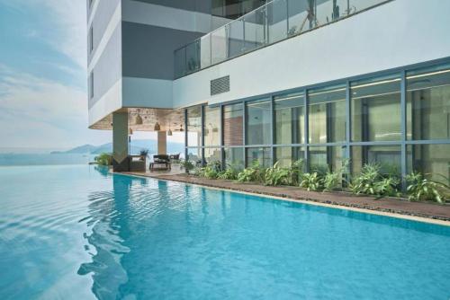a large building with a swimming pool next to the water at Panorama Sky Blue Nha Trang in Nha Trang