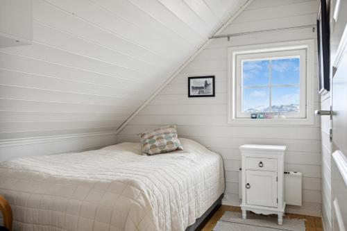 - une petite chambre avec un lit et une fenêtre dans l'établissement Idyllisk hus ved sjøen, à Hammerfest