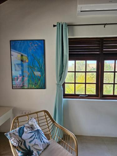 a room with a bed and a window with a curtain at Villa San Sebastian Curaçao in Fontein