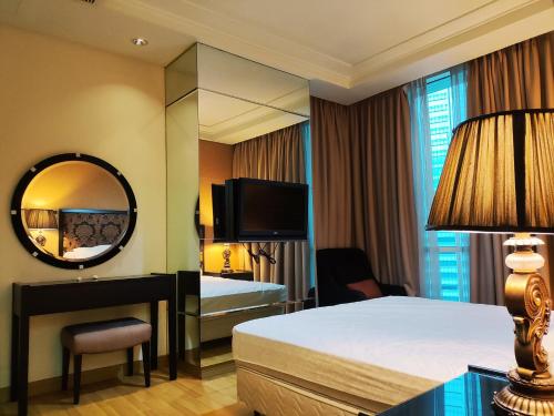um quarto de hotel com uma cama e um espelho em Apartement The Peak Sudirman em Jacarta
