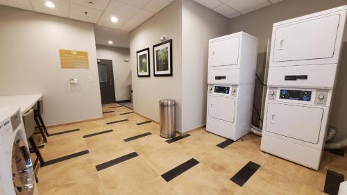 uma lavandaria com electrodomésticos brancos e piso em azulejo em Candlewood Suites - Lake Charles South, an IHG Hotel em Lake Charles