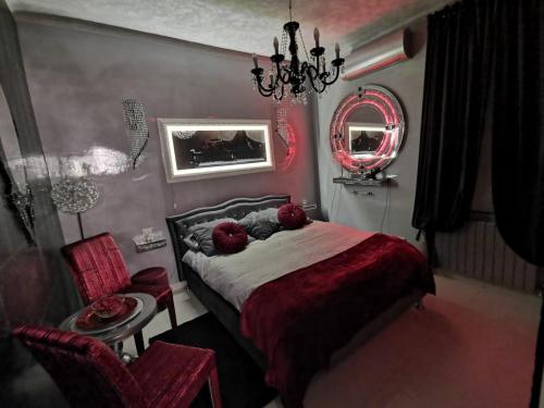 ein Schlafzimmer mit einem Bett, einem Spiegel und einem Stuhl in der Unterkunft Jacuzzi Love SuiteSweetRome in Rom