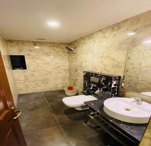 a bathroom with two sinks and a toilet at DFRONT GOLDEN PALACE in Nāmakkal