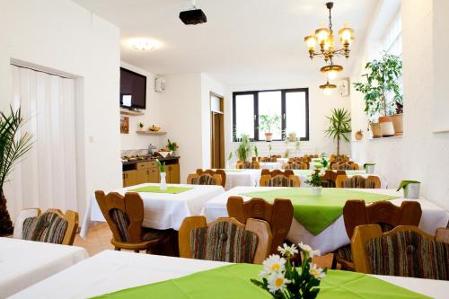 a large room with tables and chairs with green table cloth at Hotel Kreuz in Schwäbisch Gmünd