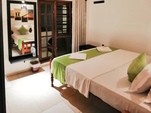 een slaapkamer met een groot bed en een spiegel bij Villa One64 Beach Front Ground Floor 2BR Apartment in Hikkaduwa