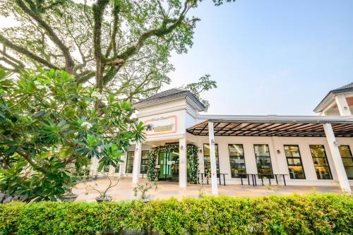 a white building with trees in front of it at Hotel Seoul in Clark
