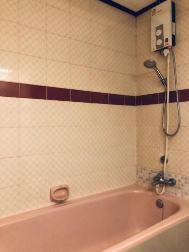 a bathroom with a pink bath tub with a shower at At Bangkok Hotel in Bangkok