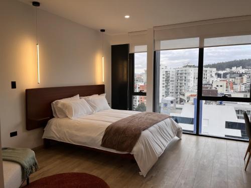 a bedroom with a large bed and a large window at Apartamento de Lujo en Quito in Quito