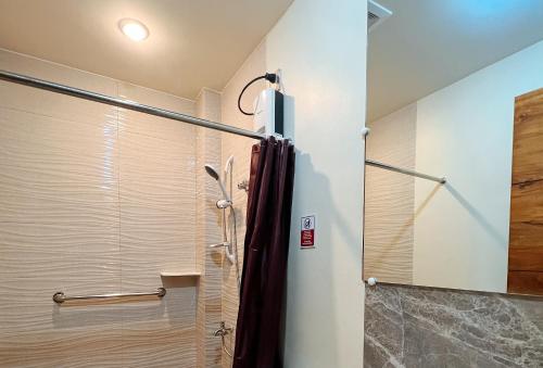 um chuveiro com uma porta de vidro na casa de banho em RedDoorz @ Washington Guest House Olongapo em Olongapo
