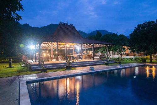 a building with a swimming pool at night at The Joglo By The Beach Pemuteran Bali in Pemuteran