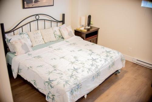 a bedroom with a bed with a white comforter at Cozy One bedroom Apartment in Moncton