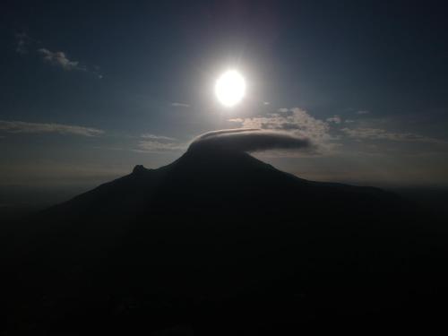 a view of a mountain with the sun in the sky at RPM home stay in Tiruvannāmalai