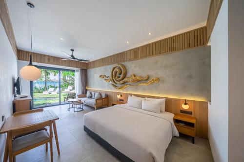 a hotel room with a bed and a desk and a chair at The Wave in Canggu