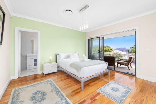 une chambre blanche avec un lit et un balcon dans l'établissement Nelson Bay Aqua Haven, à Nelson Bay