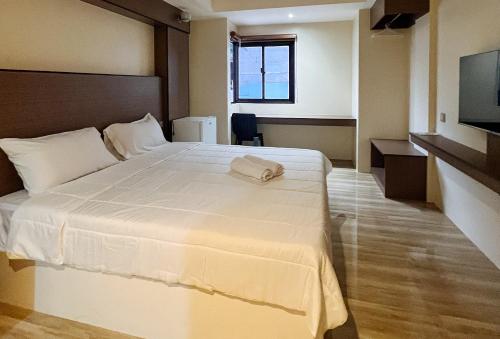 a bedroom with a large white bed with a flat screen tv at RedDoorz @ Washington Guest House Olongapo in Olongapo
