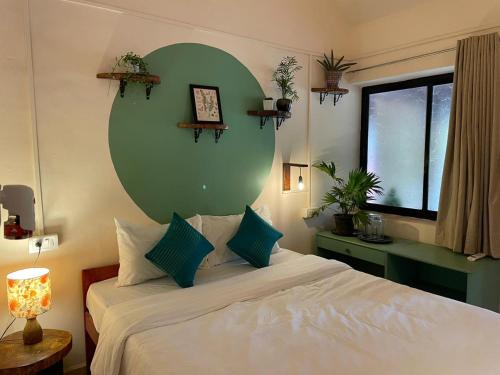 a bedroom with a large bed with a green wall at Terraria Stay and Cafe in Canacona