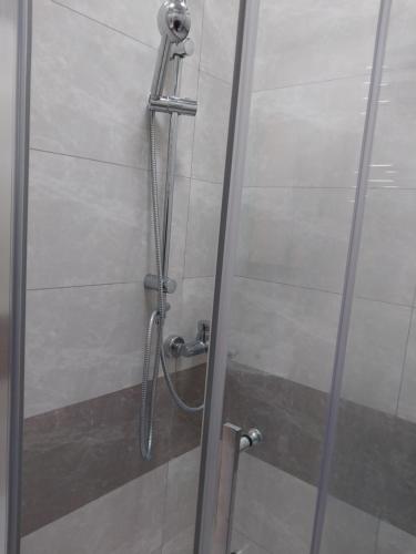 y baño con ducha y puerta de cristal. en Banu House, en Sumqayit