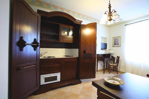a kitchen with a large wooden cabinet with a sink at Residenze L'Uncinaia Holiday House in Perugia