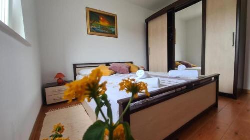 een slaapkamer met een bed en een vaas met bloemen bij Apartments Marin - amazing sea view in Splitska