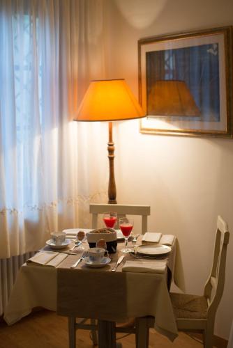 a table with a lamp and two glasses of wine at Residenze L'Uncinaia Holiday House in Perugia