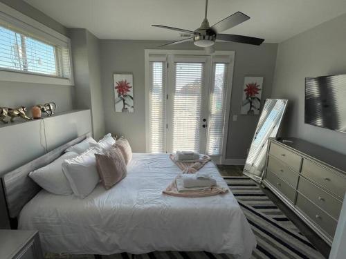 Un dormitorio con una cama blanca con ventilador de techo. en Pet friendly Wi-Fi luxury gated community downtown Greenville, en Greenville