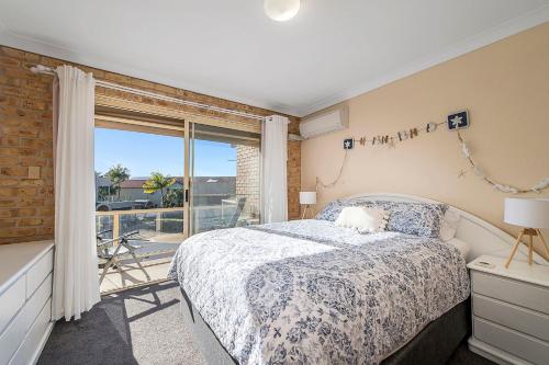 a bedroom with a bed and a large window at Ocean Shores 2 in South West Rocks