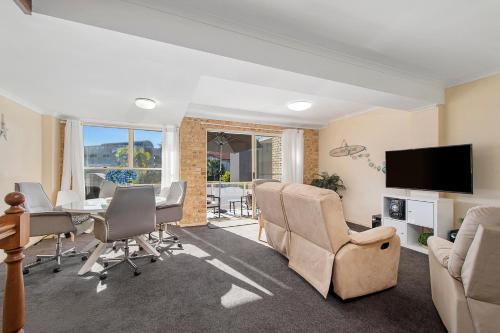 a living room with a table and chairs and a television at Ocean Shores 2 South West Rocks - No Sheets or Towels provided in South West Rocks