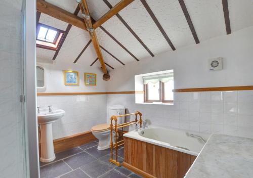 a bathroom with a tub and a toilet and a sink at The Granary in Caernarfon