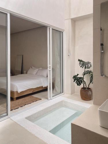 a bathroom with a tub with a bed in a room at AMBERGRIS in Tuy Hoa