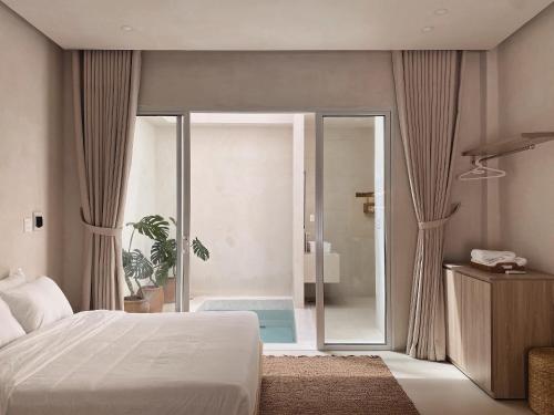 a bedroom with a bed and a glass door leading to a shower at AMBERGRIS in Liên Trì (3)