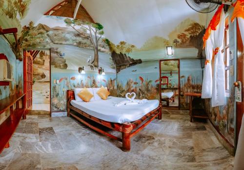 a bedroom with a bed in a room with a mural at Kokosnuss Garden Resort in Coron