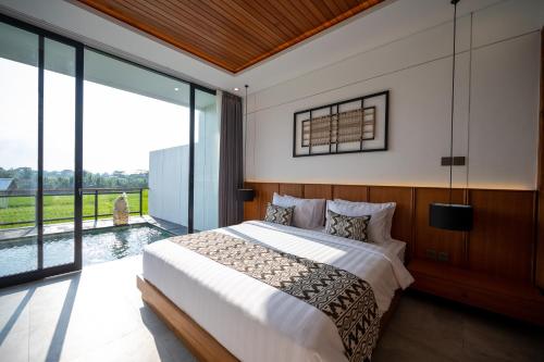 a bedroom with a large bed and a pool at Kairos Villa Ubud by Omkara Experience in Ubud