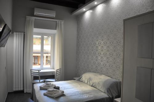 un dormitorio con una cama y una ventana en Imperial Relais, en Roma