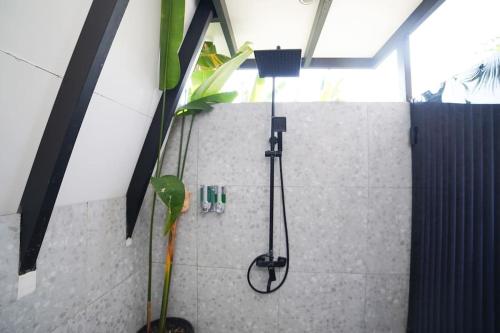 a shower in a bathroom with a plant at Ubu Villa Coconut 102 - in Yogyakarta in Yogyakarta