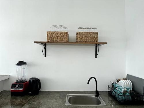 a kitchen counter with a sink and a shelf with baskets at Pawikan Seaview Villa with breakfast in Moalboal
