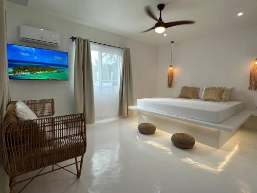 a white bedroom with a large bed and a chair at Pawikan Seaview Villa with breakfast in Moalboal