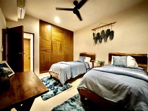 a bedroom with two beds and a ceiling fan at *Tulum 2BR w/ Pool, Gym, Security, Walk to Town in Tulum